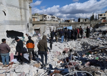 People search through the rubble of collapsed buildings where a newborn girl was found in the town of Jinderis, Aleppo province, Syria, Tuesday, Feb. 7, 2023. Residents in the northwest Syrian town discovered the crying infant, whose mother gave birth to her while buried underneath the rubble of a five-story apartment building leveled by this week's devastating earthquake, relatives and a doctor say. (AP Photo/Ghaith Alsayed)