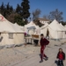 Children walk past tents in a makeshift camp in Antakya, southern Turkey, on February 22, 2023. - A 6.4-magnitude earthquake has rocked Turkey's southern province of Hatay and northern Syria, killing six people and sparking fresh panic after a massive February 6 tremor left nearly 45,000 dead in both countries. (Photo by Sameer Al-DOUMY / AFP)