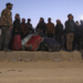 Syrian refugees living in Turkey wait by their belongings for transportation at the northern Bab al-Hawa border crossing, on February 17, 2023, as they return to Syria in the aftermath of a deadly earthquake. - Turkey this week allowed Syrians under its protection who hold ID cards from one of the quake-hit provinces to leave for between three and six months, a rule change designed to reunite families on both sides of the border hit by the February 6 disaster, which has killed more than 41,000 people and displaced millions across both countries. (Photo by Omar HAJ KADOUR / AFP)