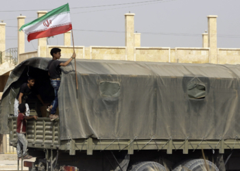 A Syrian boy holds the Iranian flag as a truck carrying aid provided by Iran arrives in the eastern city of Deir Ezzor on September 20, 2017 while Syrian government forces continue to press forward with Russian air cover in the offensive against Islamic State group jihadists across the province.
Two separate offensives are under way against the jihadists in the area -- one by the US-backed Syrian Democratic Forces, the other by Russian-backed government forces. The Syrian army now controls around 70 percent of the city and is battling to oust IS from the remainder, according to the Britain-based Observatory.
 / AFP PHOTO / LOUAI BESHARA        (Photo credit should read LOUAI BESHARA/AFP via Getty Images)