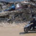 A man rides a motorbike past destroyed buildings in Antakya, southeastern Turkey, Tuesday, Feb. 21, 2023. The death toll in Turkey and Syria rose to eight in a new and powerful earthquake that struck two weeks after a devastating temblor killed nearly 45,000 people, authorities and media said Tuesday. (AP Photo/Unal Cam)