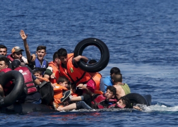 Syrian and Afghan refugees fall into the sea after their dinghy deflated some 100m away before reaching the Greek island of Lesbos, September 13, 2015. Of the record total of 432,761 refugees and migrants making the perilous journey across the Mediterranean to Europe so far this year, an estimated 309,000 people had arrived by sea in Greece, the International Organization for Migration (IMO) said on Friday. About half of those crossing the Mediterranean are Syrians fleeing civil war, according to the United Nations refugee agency. REUTERS/Alkis Konstantinidis      TPX IMAGES OF THE DAY      - RTSUQ8