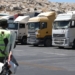 A convoy of trucks carrying humanitarian aid is seen parked after crossing the Syrian Bab al-Hawa border crossing with Turkey, on July 10, 2023. Negotiations continued at the United Nations on July 10, 2023, as officials scrambled to reach a last-minute agreement on extending vital cross-border aid to millions of people in Syria, according to diplomatic sources. A vote on the deal's extension, originally scheduled for 10:00 am (1400 GMT) Monday, "has been postponed to allow for further consultation among Security Council members," the British UN mission, which heads the council this month, said on Twitter. (Photo by OMAR HAJ KADOUR / AFP)