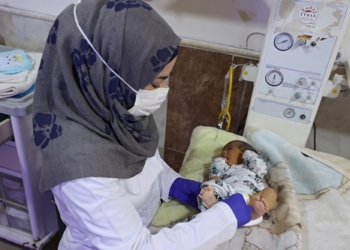 A nurse takes care of a newborn at the al-Rahma Hospital in the Syrian town of Darkush, in the Idlib province, on January 16, 2022. - In a northwest Syria hospital that provides free healthcare to around 30,000 people a month, the flow of patients rarely stops and yet the facility is slated to stop services. The Darkush hospital located in Idlib province is one of many hospitals in the region that risks closing down because of dwindling foreign aid that is causing shortages in medicine and equipment. (Photo by OMAR HAJ KADOUR / AFP)