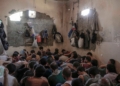 FILE - In this July 18, 2017 file photo, suspected Islamic State members sit inside a small room in a prison south of Mosul. The IS erupted from the chaos of Syria and Iraq's conflicts and swiftly did what no Islamic militant group had done before, conquering a giant stretch of territory and declaring itself a "caliphate." U.S. officials said late Saturday, Oct. 26, 2019 that their shadowy leader Abu Bakr al-Baghdadi was the target of an American raid in Syria and may have died in an explosion. (AP Photo/Bram Janssen, File)