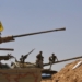 Syrian forces members stand on a tank next to vehicles waiting to transport Islamic State (IS) group members in the Qara area in Syria's Qalamoun region on August 28, 2017 as part of a deal between Hezbollah and IS fighters where the jihadists would leave to eastern Syria.
Syria's state news agency SANA, quoting a military source, confirmed Hezbollah and IS had agreed that "the remaining Daesh (IS) fighters will leave to eastern Syria". And a Lebanese military source told AFP the jihadist group would quit territory it held in eastern Lebanon.
 / AFP PHOTO / Louai Beshara        (Photo credit should read LOUAI BESHARA/AFP/Getty Images)