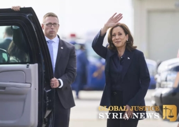 Vice President Harris waves after landing in Flint, Mich., on Oct. 4.