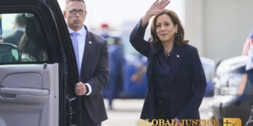 Vice President Harris waves after landing in Flint, Mich., on Oct. 4.